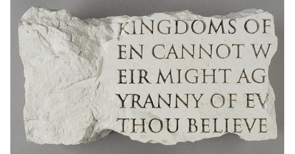 A broken slab of marble with words carved into it.
