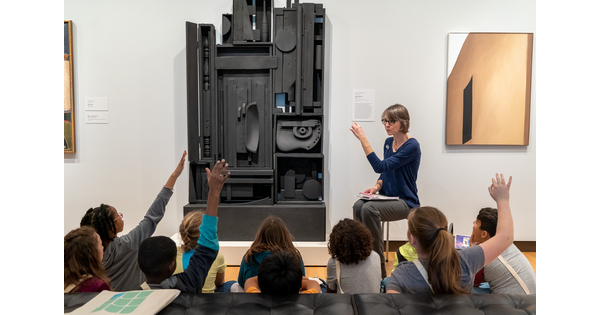 Students at the Carter sit on a gallery floor in front of a Gallery Teacher.