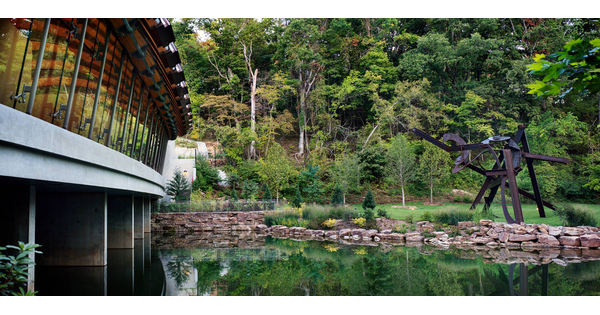 View of Crystal Bridges Museum of American art showing garden and outdoor sculpture.