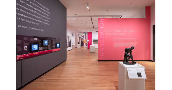 Exhibition installation photo showing title wall and galleries for &quot;Emancipation: The Unfinished Project of Liberation.&quot;
