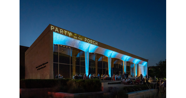 The facade of the Carter lit with blue lights and crowds of people on the porch and steps.