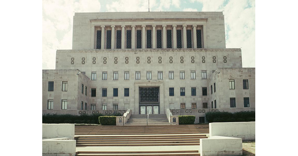 A multi-story stone building sits at the top of wide flights of steps.