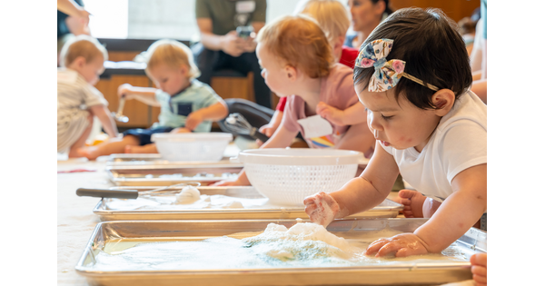 Babies and young toddlers put their hands in soap bubbles in the Carter&#039;s Family Pop-up Space.