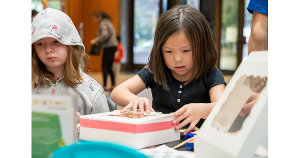 Children make art at a table in the Carter&#039;s Atrium.