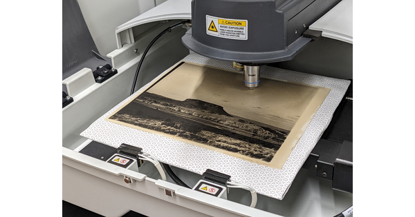 A black-and-white photograph on a tray under a machine that looks a bit like a microscope.