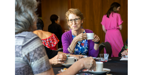 A group of people drink tea at tables in the Carter&#039;s Lounge.