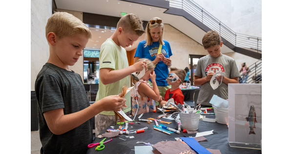 An adult and five children make art at a table in the Carter&#039;s Atrium.