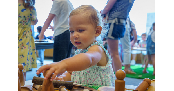 A baby plays with blocks on the floor of the Carter&#039;s Family Pop-up space.