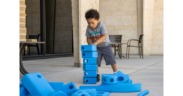 A child plays with blue building blocks on the Carter&#039;s porch.