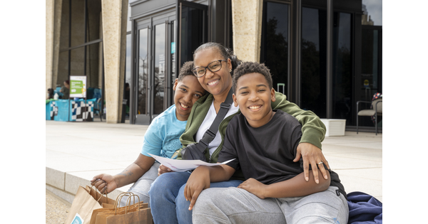 An adult and two pre-teens sit on the Carter&#039;s porch.