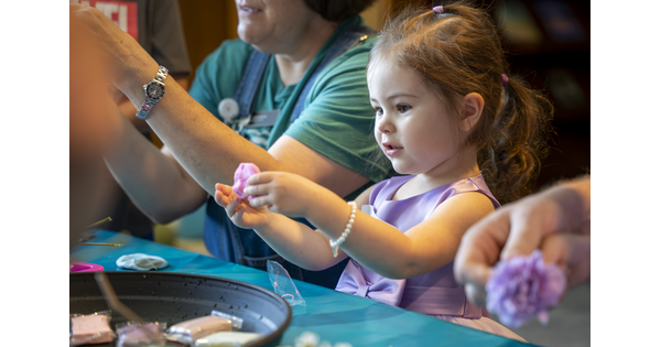 A White child works on an art project at a table in the Carter&#039;s Pop-up Lounge.