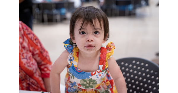 A close-up of a young child on an adult's lap in the Carter's Atrium.