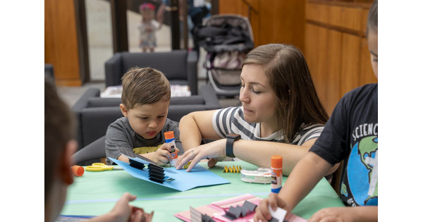 A young White woman and a child make art at a table in the Carter's Library.