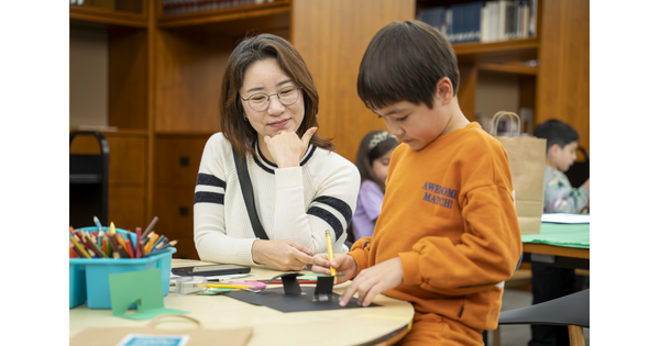 A woman and a child, both with Asian features, make artwork at a table in the Carter Library.