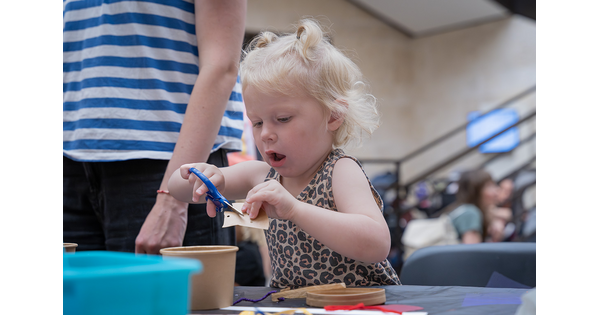 A young child makes art in the Carter's Atrium.