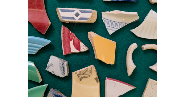 Pieces of ceramic laying on a green cloth.