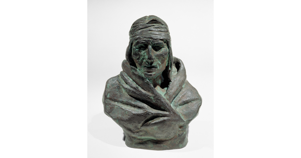 A bronze bust of a Native American man wrapped in a blanket.