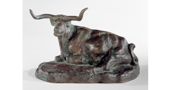 A bronze sculpture of a longhorn steer resting on the ground.
