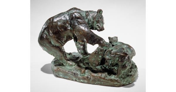 A bronze sculpture of a bear and its cub pawing an upturned rock.