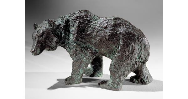 A bronze sculpture of a walking bear.