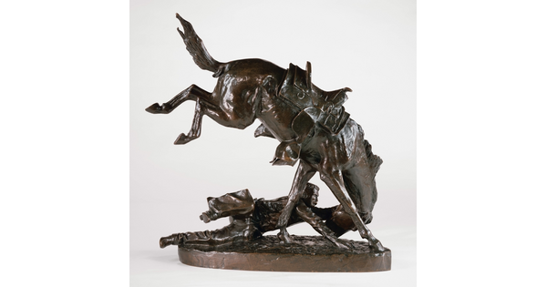 A bronze sculpture of a man on the ground hanging on to the head of his bucking horse.