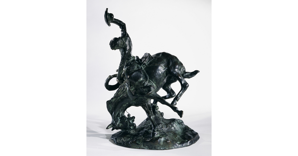 A bronze sculpture of a cowboy trying to ride a bucking horse.