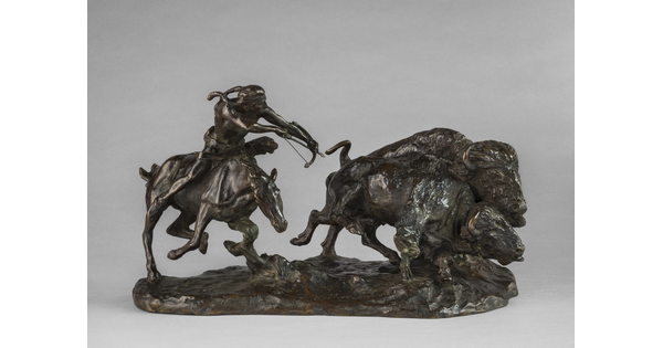 A bronze sculpture of a Native American on horseback hunting bison with a bow and arrow.A bronze sculpture of a Native American on horseback hunting bison with a bow and arrow.