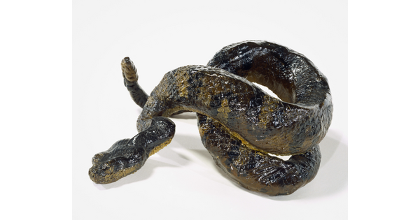 A painted sculpture of a coiled, multicolored rattlesnake.