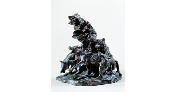 A bronze sculpture of an emaciated person wrapped in blankets surrounded by three snarling wolves.