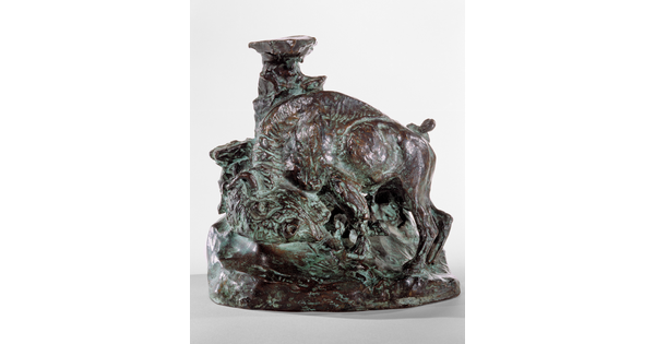 A bronze sculpture of a bison, head bent toward the ground, leaning against what might be a tree trunk to scratch its shoulder.