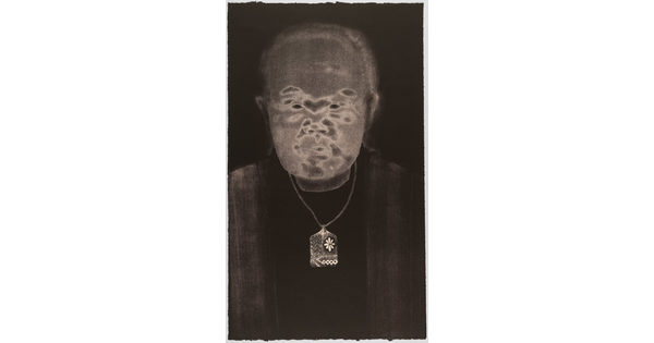 A black-and-white print of an abstracted man with Asian features, a gray face, and wearing a delicate patterned necklace all on a black background.