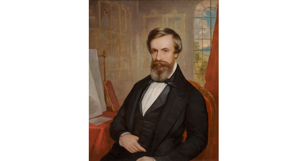 An oil painting of a White man with brown hair and beard wearing bow tie and jacket; artwork hangs salon-style on the walls behind him.