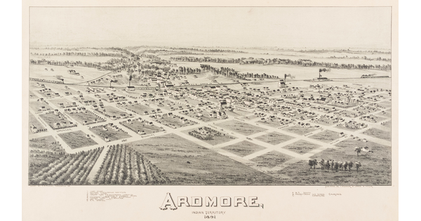 A black-and-white print of an aerial view of a town on a plains showing the grid of streets, buildings, and a railroad running through the center.