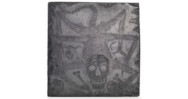 An engraved metal printing plate of a spider with a skull as a head, holding bones and skulls in its claws.