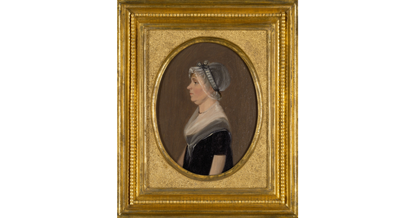 An oil painting in a gold frame of a White woman in profile wearing a sheer bonnet and black dress with a sheer scarf around her neck and shoulders.