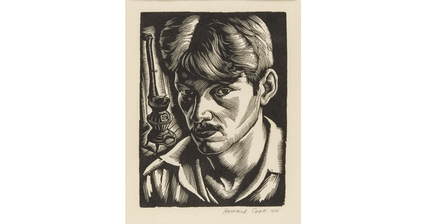 A black-and-white print of a close-up of a White man with a mustache wearing an open collar shirt; a pot-bellied stove in the background.