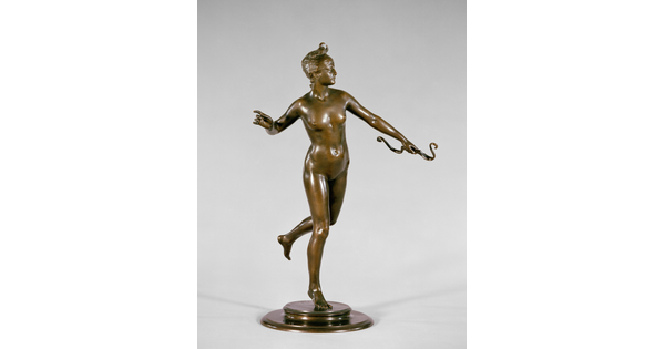 A bronze sculpture of a nude, female archer in motion.