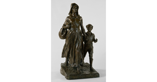 A bronze sculpture of a woman wearing pioneer clothing holding the hand of a young boy.