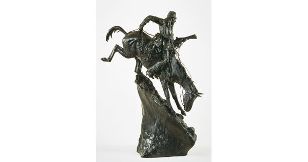 A bronze sculpture of an Indigenous man on horseback traveling down a steep mountain.