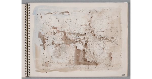 An abstract watercolor of sepia-toned splatters on a page of a bound sketchbook.