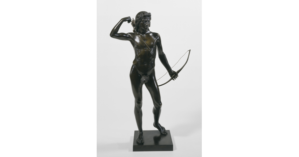 A bronze sculpture of a nude, male archer reaching for an arrow in the quiver on his back.