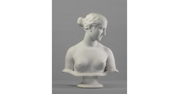 A marble bust of a bare-breasted woman, hair pulled up into a bun on the back of her head.