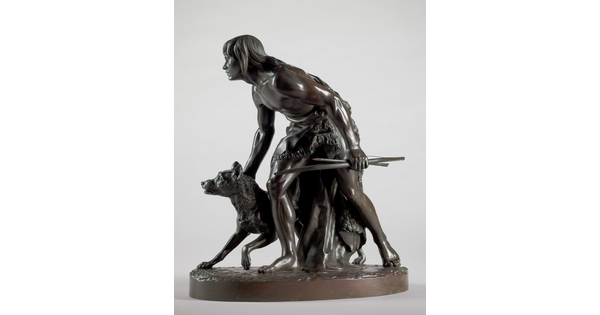 A bronze sculpture of a young Indigenous man holding a bow and arrow, standing hunched low with a dog beside him.