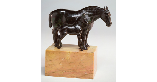 A bronze sculpture of two horses, a mare and a foal, standing next to each other on a stone base.