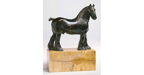 A bronze sculpture of a stallion with a bobbed tail and long hair on its legs below the knees standing on a stone base.