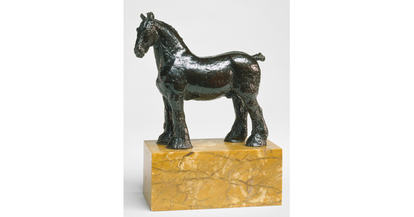 A bronze sculpture of a stallion with a bobbed tail and long hair on its legs below the knees standing on a stone base.