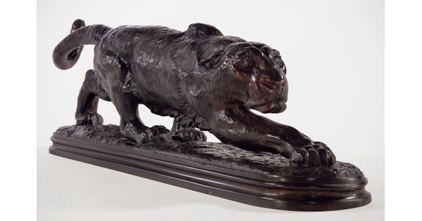 A bronze sculpture of a crouching panther with elongated body and front leg outstretched.
