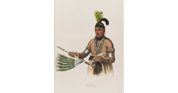 A color print of a Native American man with two peacock feathers on his head, a painted face, several medals hanging around his neck, holding a ceremonial pipe decorated with feathers.