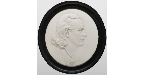 A marble cameo of a man in profile with shoulder-length wavy hair.