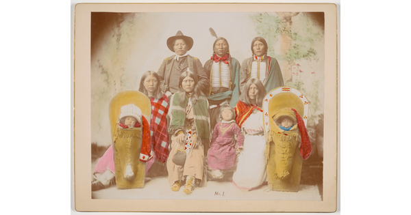 A color photograph of an Indigenous family, including two babies in cradleboards.